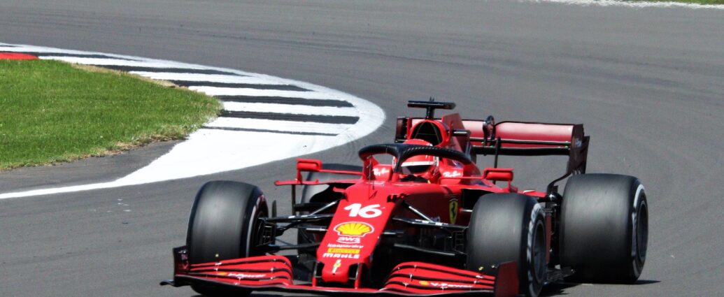 Charles Leclerc's red racing car with black wheels on racing track at Italian Grand Prix.