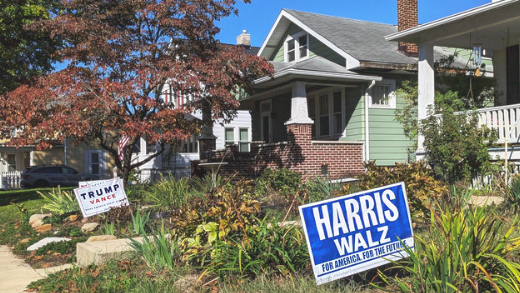 A photo of a street in Ohio, with political advertising signs in two front gardens. One says 'Trump Vance' and the other says 'Harris Walz', representing the US Vice Presidential Candidates Debate.