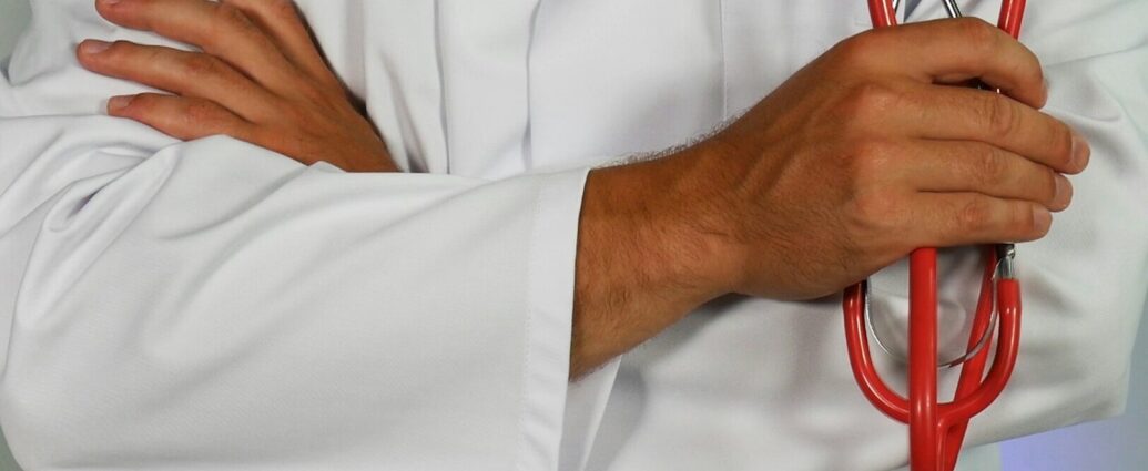 a health professionals wearing white medical jacket holding stethoscope