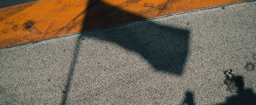 Franco Colapinto. A shadow of a Formula One flag on concrete floor.