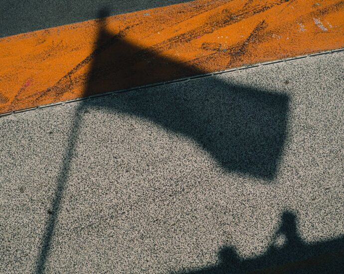 Franco Colapinto. A shadow of a Formula One flag on concrete floor.