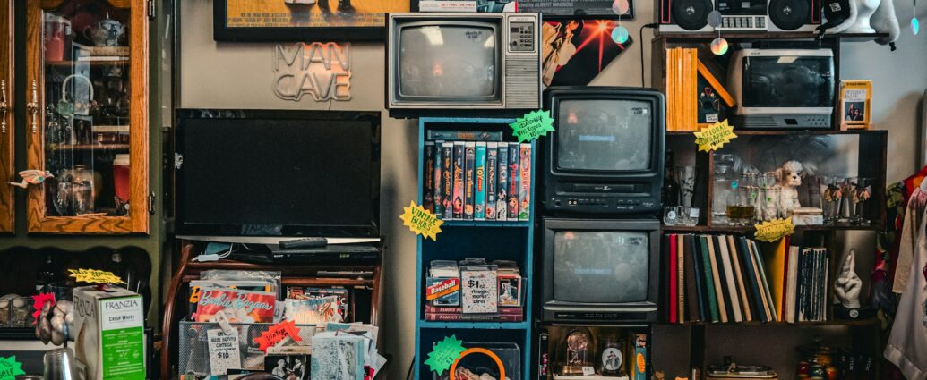 a room filled with random items of old media including a tv, radio and books