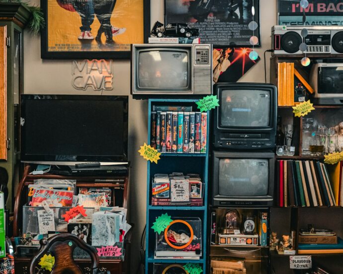 a room filled with random items of old media including a tv, radio and books