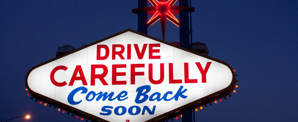 Las Vegas neon sign reading 'drive carefully' in red capital letters and 'come back soon' in blue