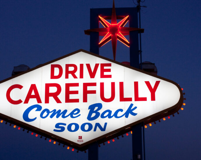 Las Vegas neon sign reading 'drive carefully' in red capital letters and 'come back soon' in blue