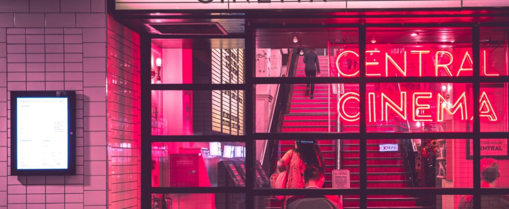 Cinema with neon sign and people sitting inside