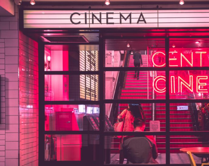 Cinema with neon sign and people sitting inside