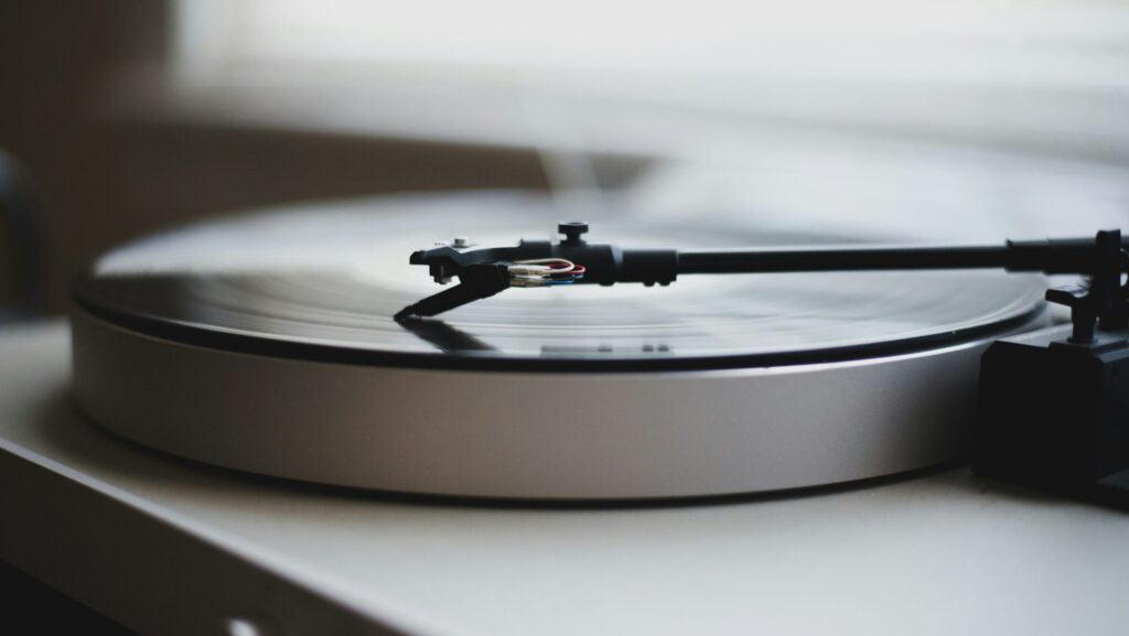 Black and white photo of a turntable promoting a review of a new single by Celeste