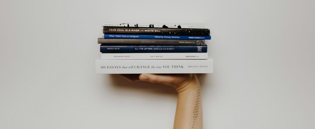 A pile of books held up in the air, balanced on an outstretched hand. Featured photo of an article