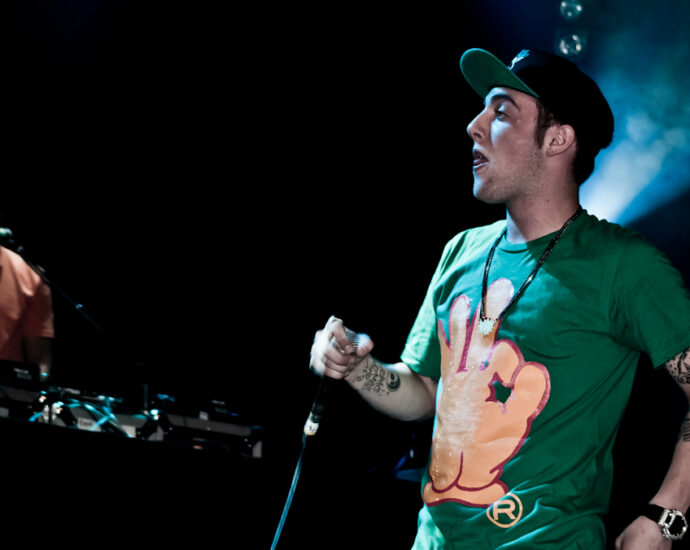 Artist and rapper Mac Miller performing at a concert on stage in green t-shirt. Promoting Balloonerism album