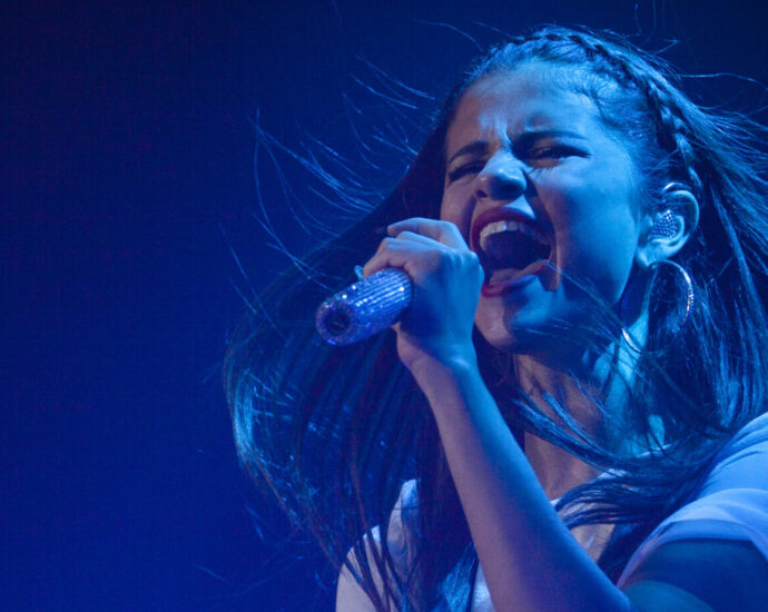 Selena Gomez singing with emotion into a microphone.