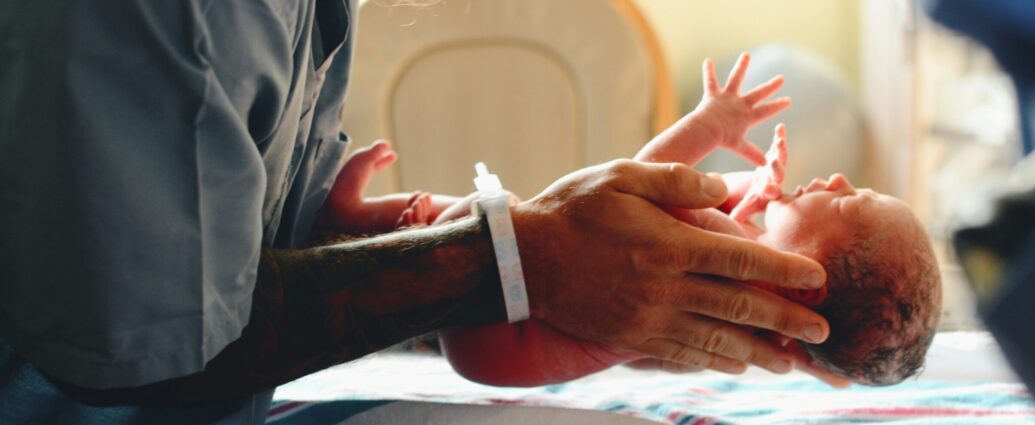 Image of a nurse lowering a baby onto a scale