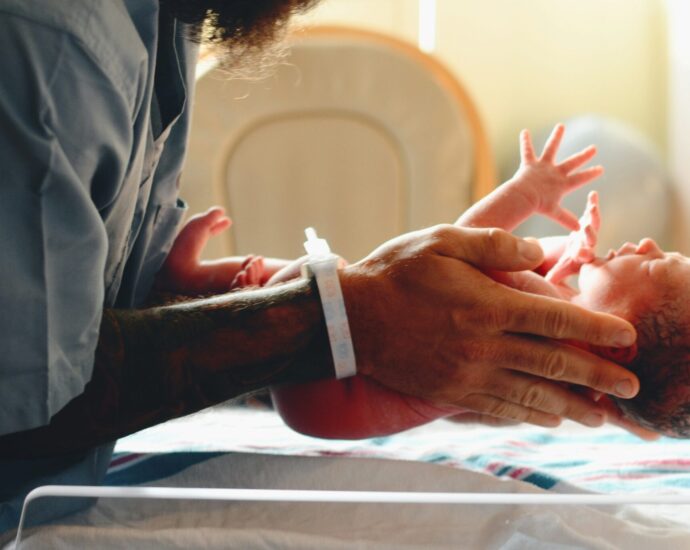 Image of a nurse lowering a baby onto a scale