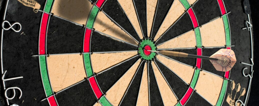 Close up photo of a darts board with a dart in it.