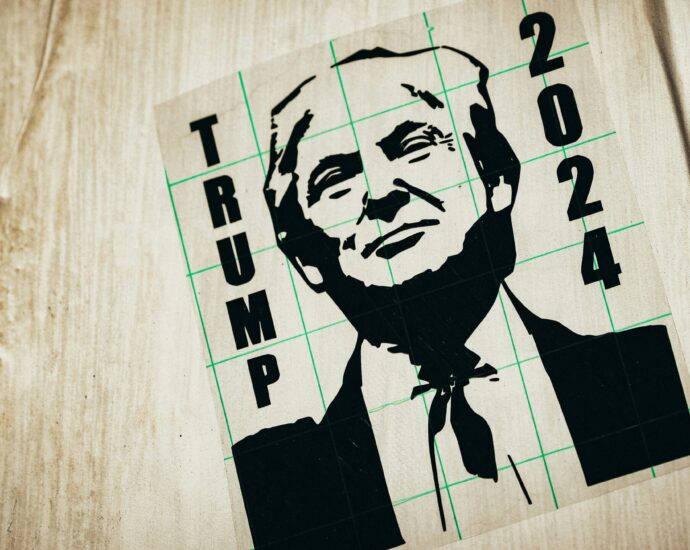 A black ink drawing of Donald Trump with the words 'Trump 2024' on a wooden surface.