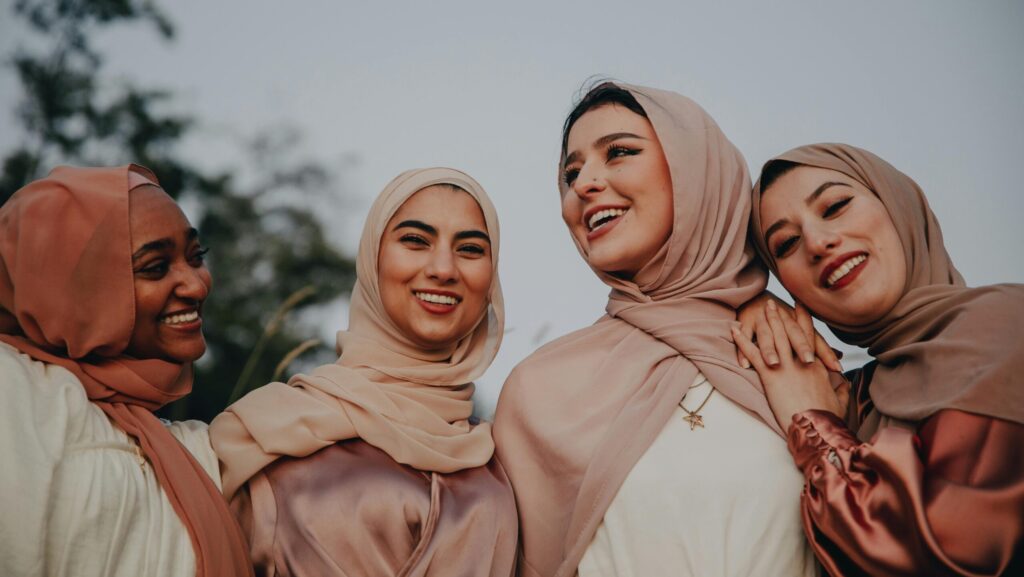 Four smiling people wearing hijabs. Promotion of an article about caring for culry hair