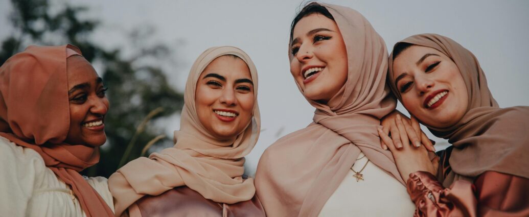 Four smiling people wearing hijabs. Promotion of an article about caring for culry hair